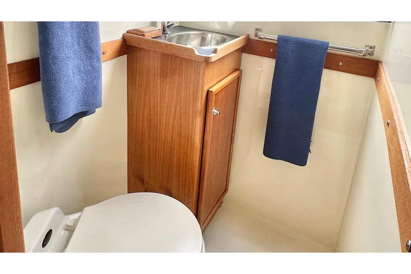 Blue Heron Yacht Photos Pics Compact bathroom in 2003 Coastal Craft 320 Cruiser with wooden cabinet and stainless steel sink.