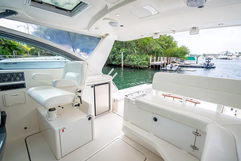  Yacht Photos Pics 2005 Tiara Yachts 4200 Open interior, featuring helm and seating, docked by a scenic waterfront.