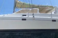 Casuarina Yacht Photos Pics 2000 Voyage Yachts Norseman 430 catamaran with sails, side view against blue sky.