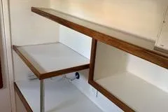 Casuarina Yacht Photos Pics Wooden shelves inside a 2000 Voyage Yachts Norseman 430, showcasing storage space.