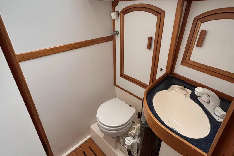 Custom Yacht Photos Pics Small boat bathroom with wooden trim, featuring a toilet and sink. Sabre 452, year 2000.