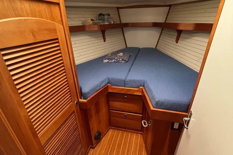 Custom Yacht Photos Pics Cozy cabin interior of 2000 Sabre 452 yacht with blue bedding and wooden finish.