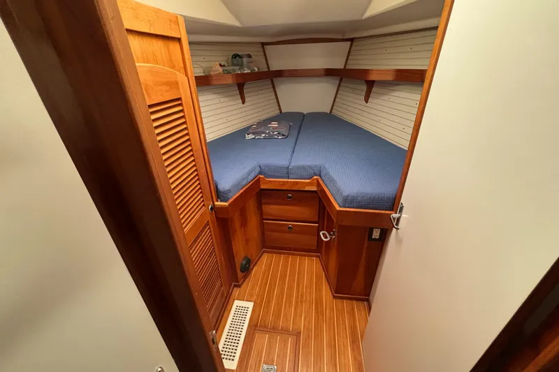 Custom Yacht Photos Pics Cozy cabin interior of 2000 Sabre 452 yacht with wooden finish and blue bedding.