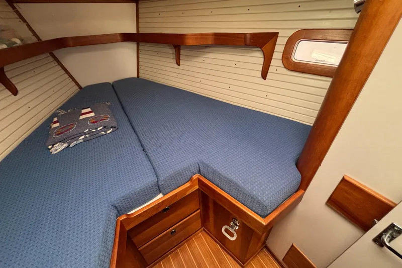 Custom Yacht Photos Pics Cozy cabin interior of 2000 Sabre 452 yacht with blue bedding and wooden accents.
