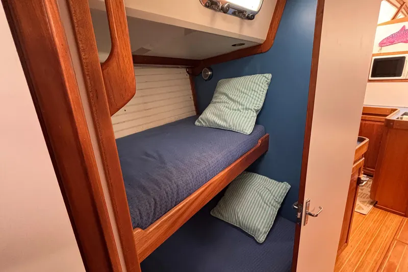 Custom Yacht Photos Pics Bunk beds in 2000 Sabre 452 yacht cabin with blue bedding and wooden accents.