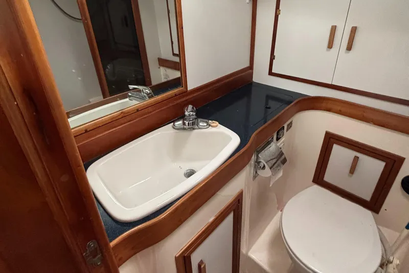 Custom Yacht Photos Pics Boat bathroom with sink, toilet, and wooden cabinetry in a 2000 Sabre 452 model.