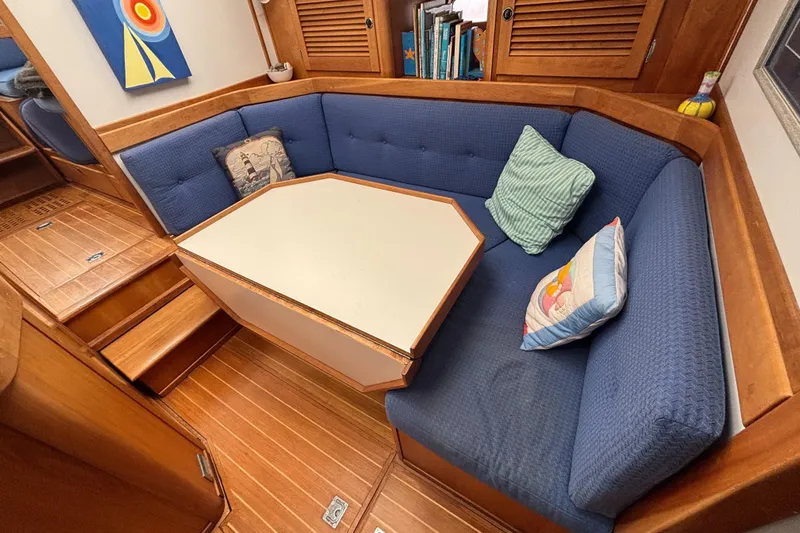 Custom Yacht Photos Pics Cozy Sabre 452 yacht interior with blue cushioned seating and wooden accents, 2000 model.