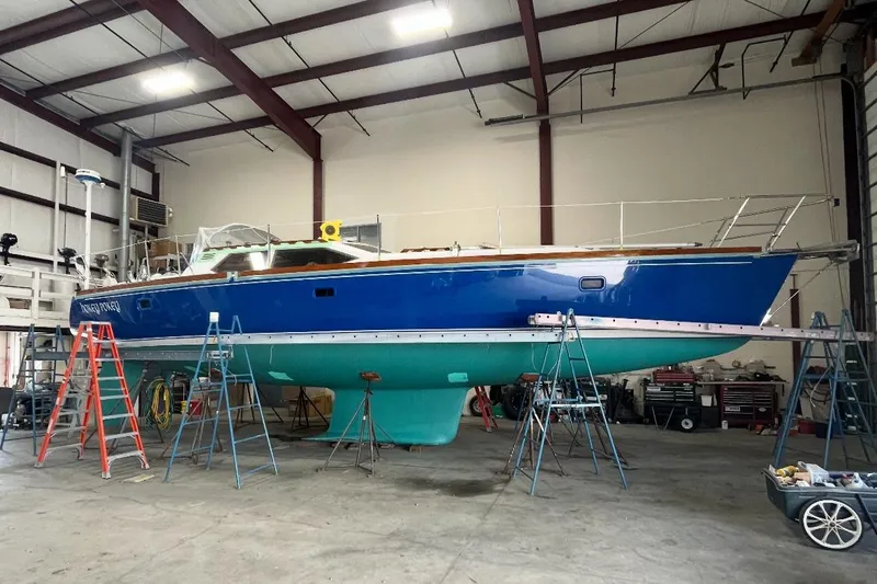 Custom Yacht Photos Pics Blue Sabre 452 sailboat from 2000 in a warehouse, elevated on stands for maintenance.