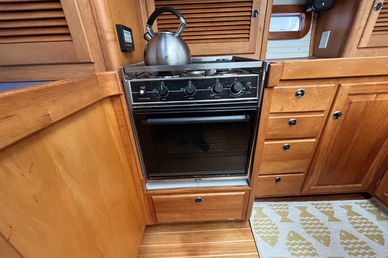 Custom Yacht Photos Pics Wooden boat kitchen with stove, kettle, and cabinets, Sabre 452, year 2000.