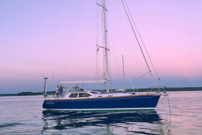 Custom Yacht Photos Pics Sailboat Sabre 452, 2000 model, on calm water at sunset with pink sky.