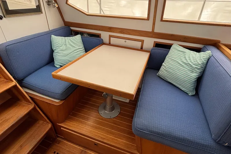 Custom Yacht Photos Pics Cozy dining area in a 2000 Sabre 452 boat with blue seating and striped cushions.