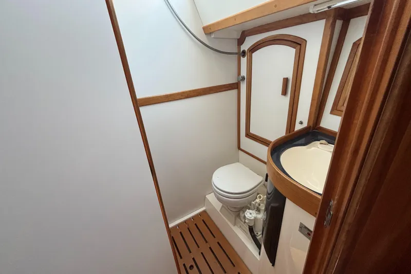 Custom Yacht Photos Pics Compact bathroom in 2000 Sabre 452 yacht with wooden accents and modern fixtures.