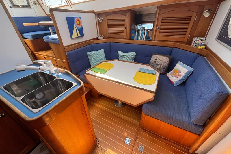 Custom Yacht Photos Pics Cozy Sabre 452 yacht interior with blue seating, dining table, and kitchenette, 2000 model.