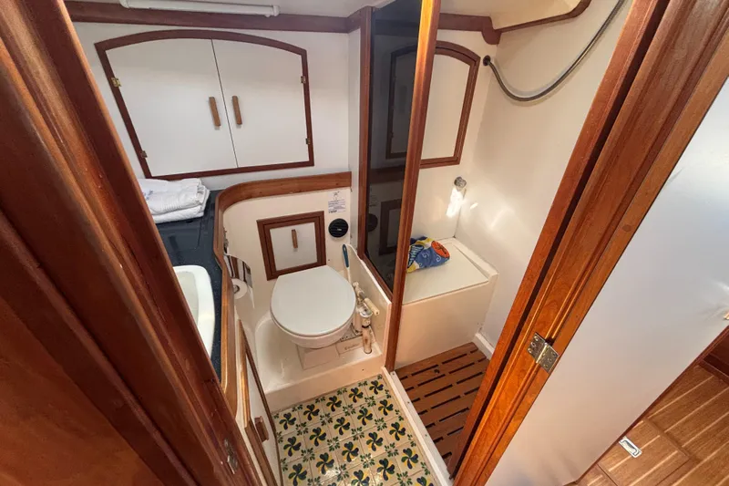 Custom Yacht Photos Pics Compact bathroom in 2000 Sabre 452 yacht with wooden accents and decorative flooring.