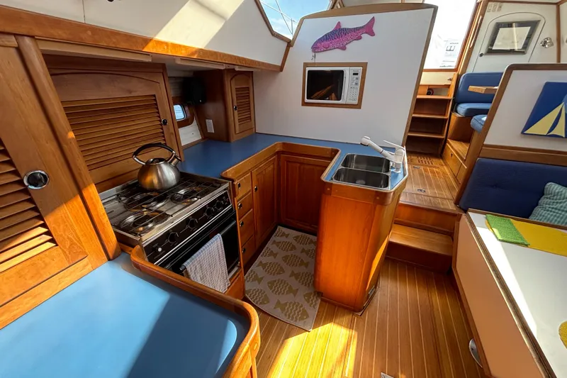 Custom Yacht Photos Pics Interior of 2000 Sabre 452 yacht kitchen with stove, sink, and wooden cabinetry.
