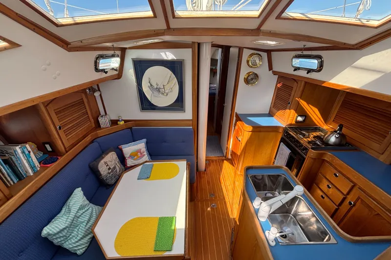 Custom Yacht Photos Pics Interior of 2000 Sabre 452 sailboat with cozy seating, kitchen, and nautical decor.