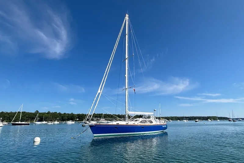 Custom Yacht Photos Pics Sailboat Sabre 452 (2000) anchored in a serene harbor under a clear blue sky.
