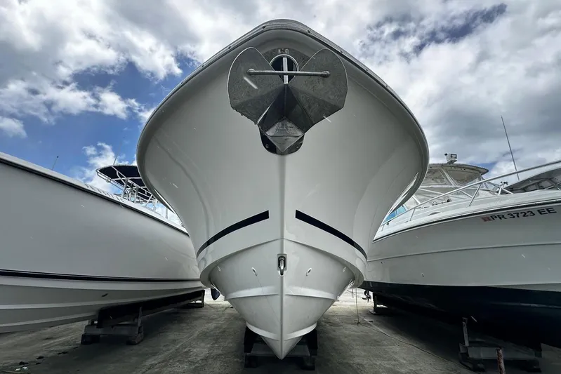  Yacht Photos Pics 2017 Boston Whaler 330 Outrage boat on dry dock under cloudy sky.