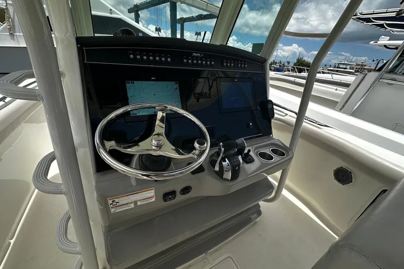  Yacht Photos Pics 2017 Boston Whaler 330 Outrage helm with steering wheel and navigation controls.