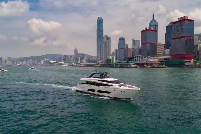 Ferretti 850 Yacht Photos Pics 2017 Ferretti Yachts 850 cruising in a bustling city harbor with skyscrapers.
