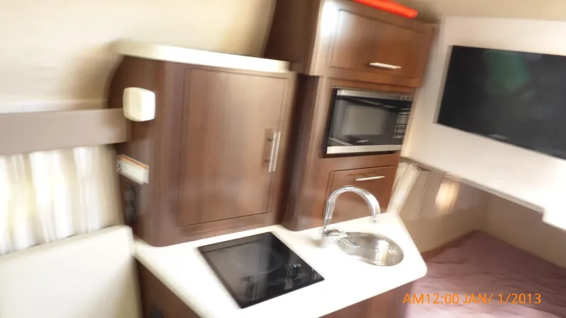  Yacht Photos Pics Interior of 2018 Regal 28 Express boat with kitchenette and TV.