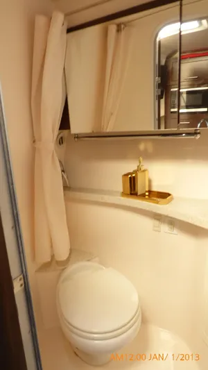  Yacht Photos Pics 2018 Regal 28 Express boat bathroom with toilet, mirror, and gold accents.