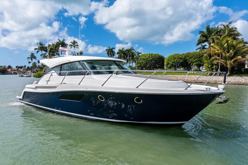 Southwind Yacht Photos Pics 2018 Tiara Yachts C44 Coupe cruising on a sunny day with palm trees in the background.
