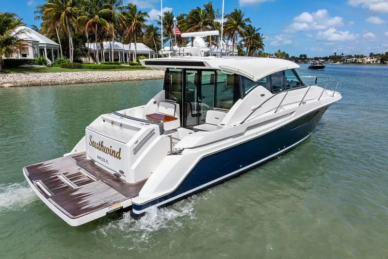 Southwind Yacht Photos Pics 2018 Tiara Yachts C44 Coupe cruising in tropical waters near palm trees.