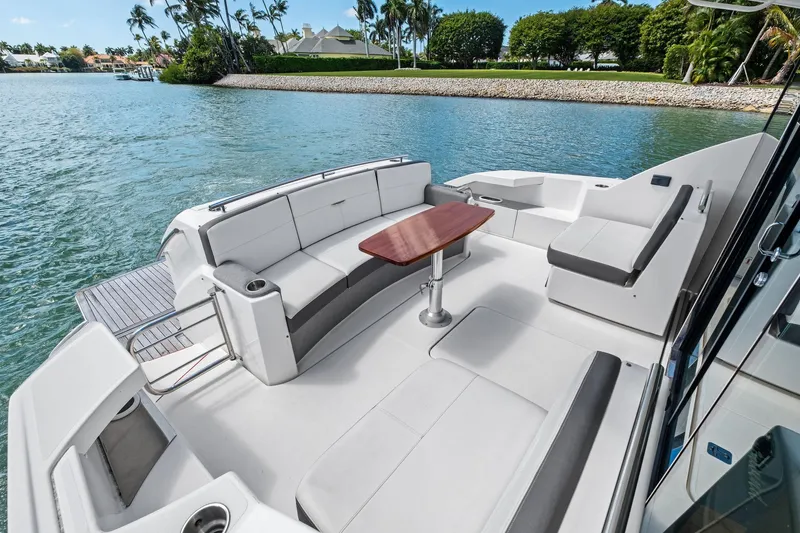 Southwind Yacht Photos Pics 2018 Tiara Yachts C44 Coupe, elegant deck with seating and table, scenic waterfront view.
