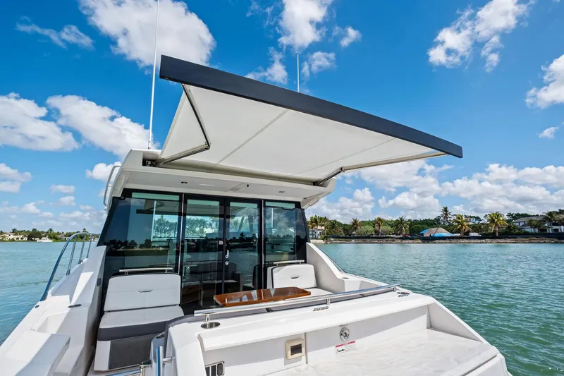 Southwind Yacht Photos Pics 2018 Tiara Yachts C44 Coupe on water, featuring spacious deck and retractable awning.