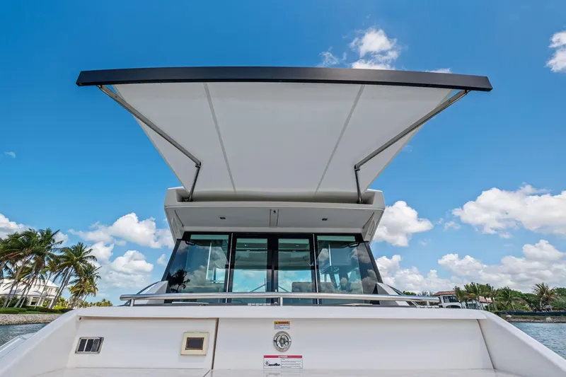Southwind Yacht Photos Pics 2018 Tiara Yachts C44 Coupe with extended sunshade, under clear blue sky.