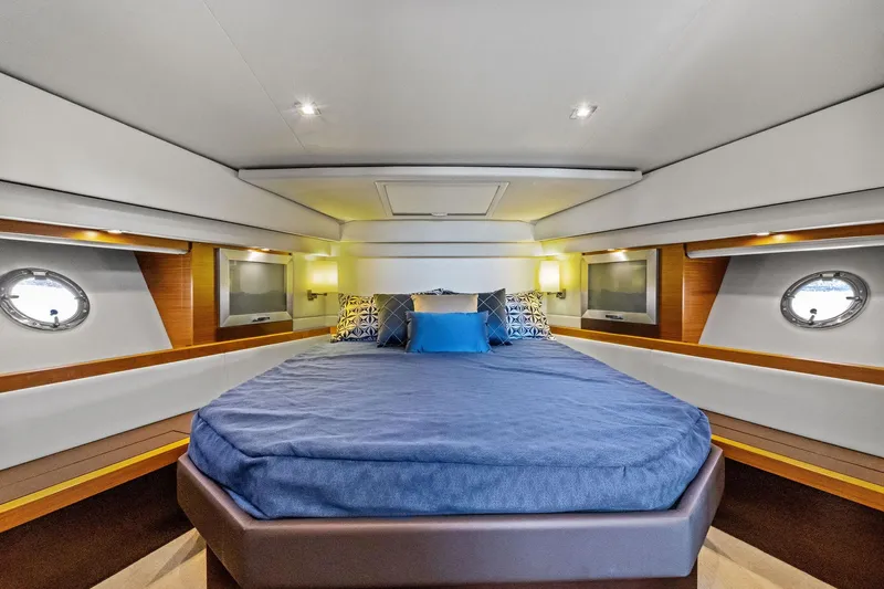 Southwind Yacht Photos Pics Luxurious bedroom interior of 2018 Tiara Yachts C44 Coupe with modern design and porthole windows.