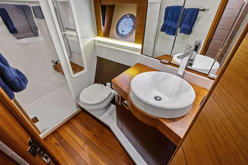 Southwind Yacht Photos Pics Luxurious bathroom in 2018 Tiara Yachts C44 Coupe with modern fixtures and wooden accents.