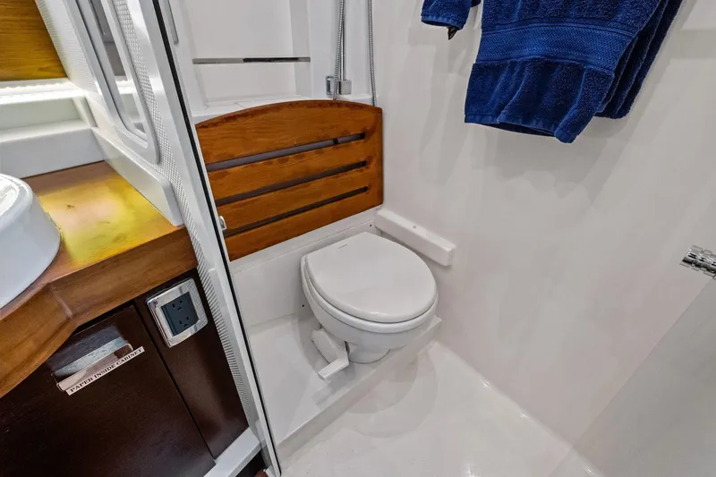 Southwind Yacht Photos Pics 2018 Tiara Yachts C44 Coupe bathroom with wooden accents and blue towels.
