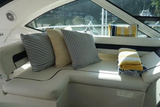 L' Aventura Yacht Photos Pics Luxurious seating area on 2010 Sea Ray 470 Sundancer with striped cushions and towels.