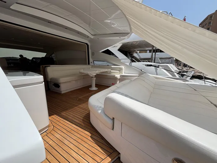  Yacht Photos Pics Luxurious 2011 Pershing 64 yacht interior with white seating and wooden deck.