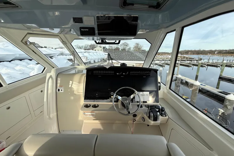 Siper Brokerage Yacht Photos Pics Interior view of 2021 Boston Whaler 380 Realm boat cockpit with steering wheel and controls.