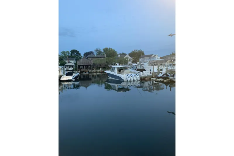 Siper Brokerage Yacht Photos Pics 2021 Boston Whaler 380 Realm docked in a serene marina setting.