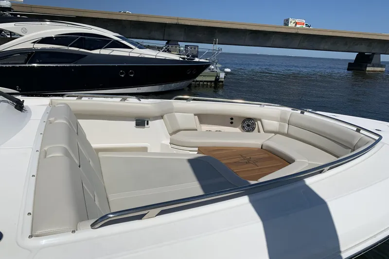 Siper Brokerage Yacht Photos Pics 2021 Boston Whaler 380 Realm boat with spacious seating area, docked near a bridge.