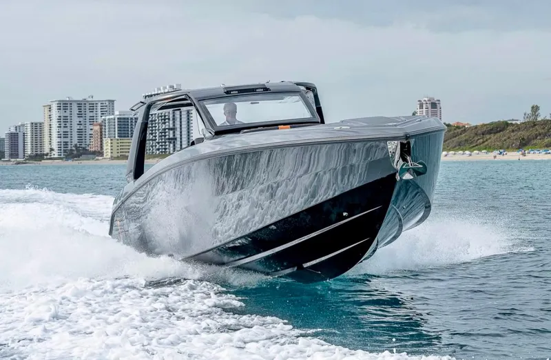  Yacht Photos Pics 2023 Cigarette 41 Nighthawk speedboat cruising on water near city skyline.