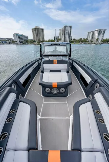  Yacht Photos Pics 2023 Cigarette 41 Nighthawk boat with sleek seating, on calm water, cityscape in background.