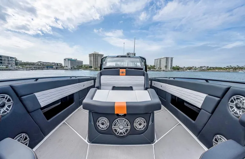  Yacht Photos Pics 2023 Cigarette 41 Nighthawk boat interior with modern seating and speakers, docked near cityscape.