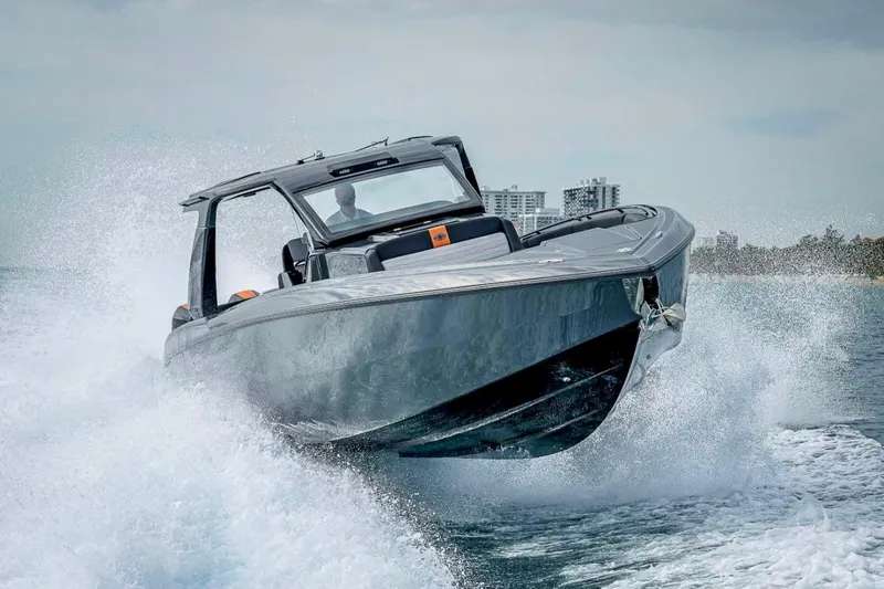  Yacht Photos Pics 2023 Cigarette 41 Nighthawk speedboat cutting through waves, showcasing sleek design and power.