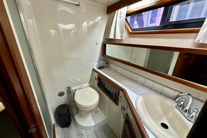 Anchored Souls Yacht Photos Pics 1988 Californian 45 Motor Yacht bathroom with toilet, sink, mirror, and window.