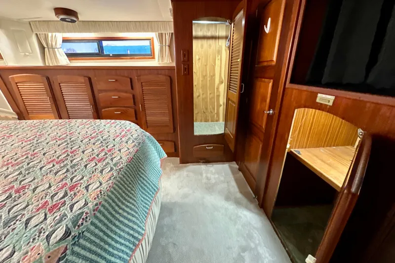 Anchored Souls Yacht Photos Pics Interior of 1988 Californian 45 Motor Yacht with wood cabinetry and patterned bedding.