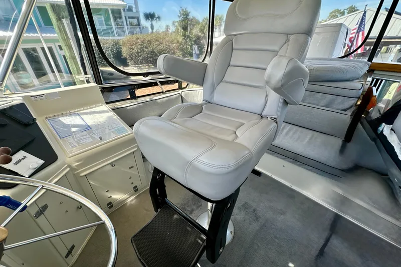 Anchored Souls Yacht Photos Pics Captain's chair in 1988 Californian 45 Motor Yacht cockpit, featuring navigation controls and panoramic windows.