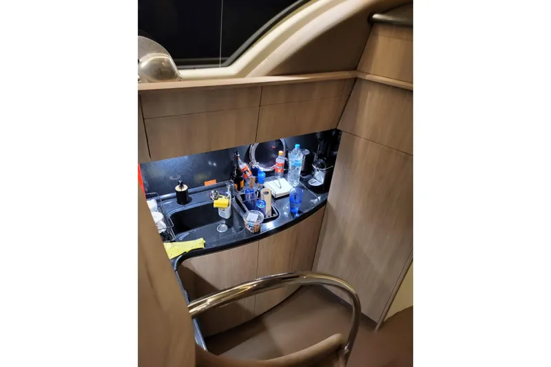 11:11 Yacht Photos Pics 2006 Azimut Fly 50 yacht kitchen with wooden cabinets and countertop clutter.