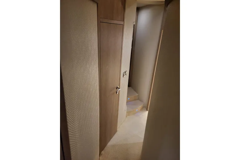 11:11 Yacht Photos Pics Interior hallway of 2006 Azimut Fly 50 yacht with wooden door and carpeted stairs.