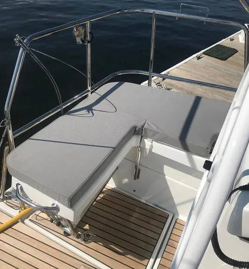  Yacht Photos Pics Jeanneau 54 (2020) yacht deck with cushioned seating and wooden flooring.