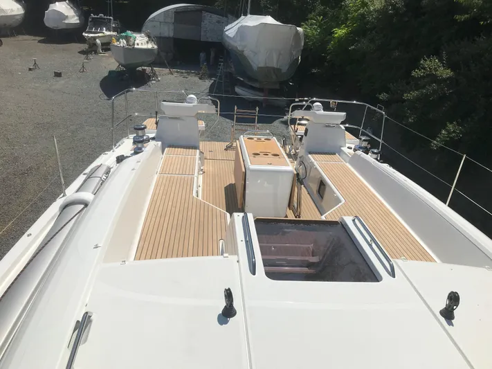  Yacht Photos Pics Jeanneau 54 yacht deck, 2020 model, with wooden flooring and outdoor seating area.